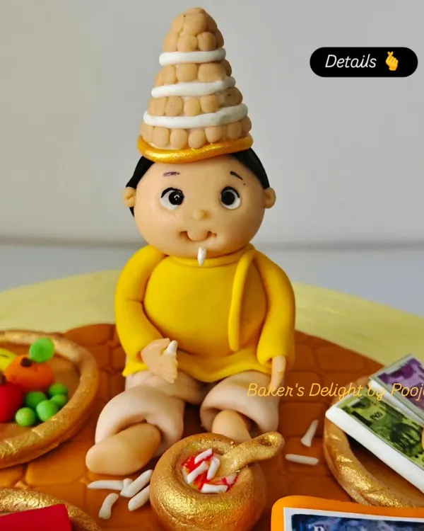 A close-up of the fondant baby topper from the Annaprashan cake. I took great care in sculpting the traditional Bengali topor (headwear) and the tiny details like the bowl of kheer.