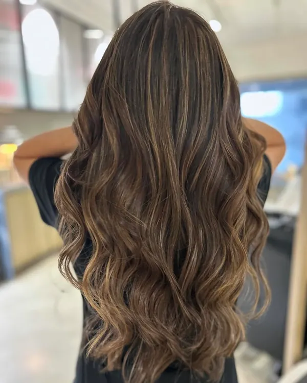 A perfect example of a total hair transformation. I gave her a long layered haircut and used a back-to-back foil technique to create these blended, three-tone highlights for a completely new and vibrant look.