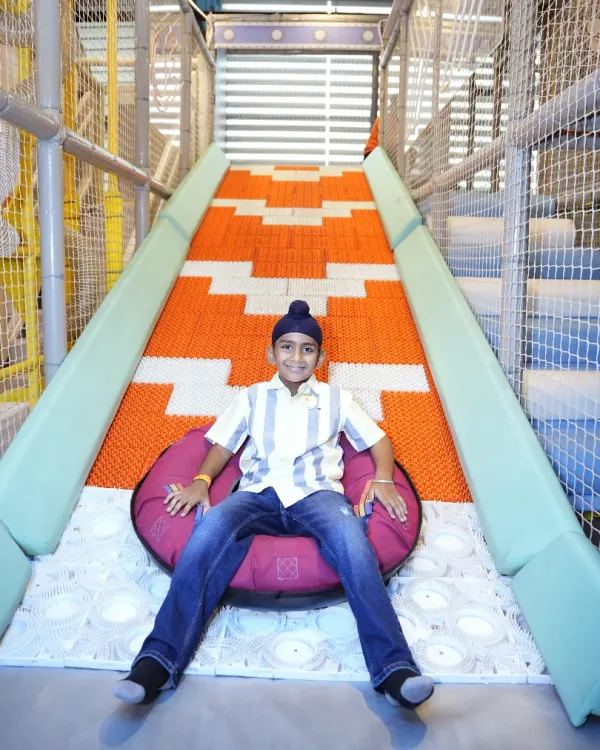 A young boy relaxes at the bottom of our famous Donut Slide, a favorite attraction for kids seeking a fun and fast ride.