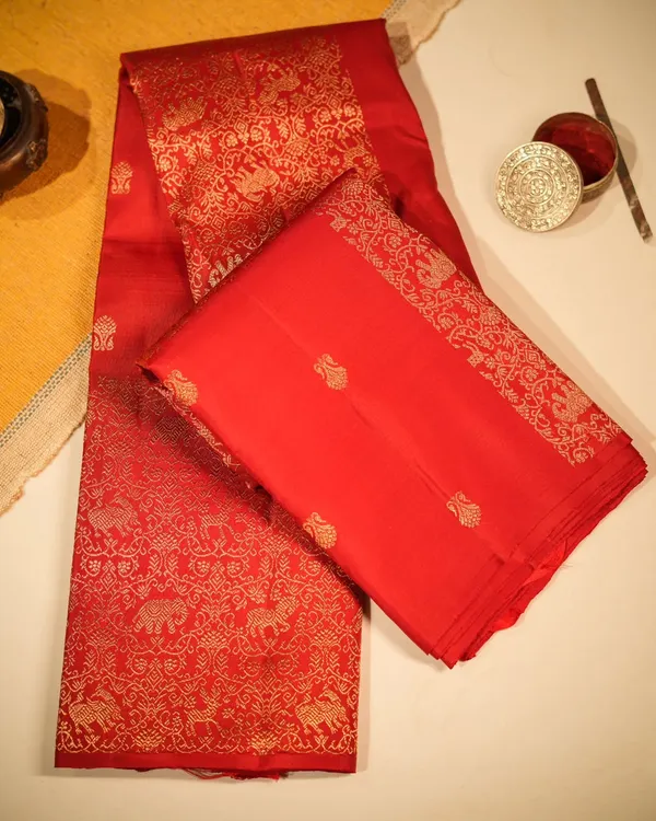 A quintessential bridal saree, this radiant red Kanjivaram is woven with a grand pallu featuring majestic elephants and horses in pure gold zari, telling a story of royalty.