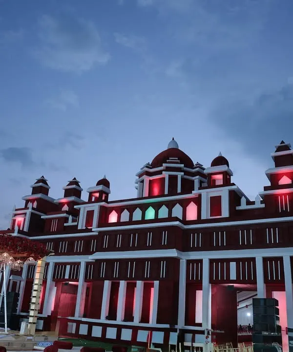 We transformed this venue by constructing a grand facade resembling a red and white Rajasthani palace, creating an immersive and royal experience from the moment guests arrived.