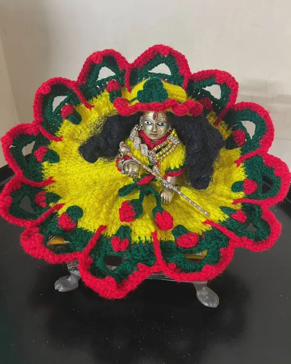 A bright and colorful woolen poshak worn by Laddu Gopal. The combination of yellow, red, and green makes it a cheerful outfit for the winter season.