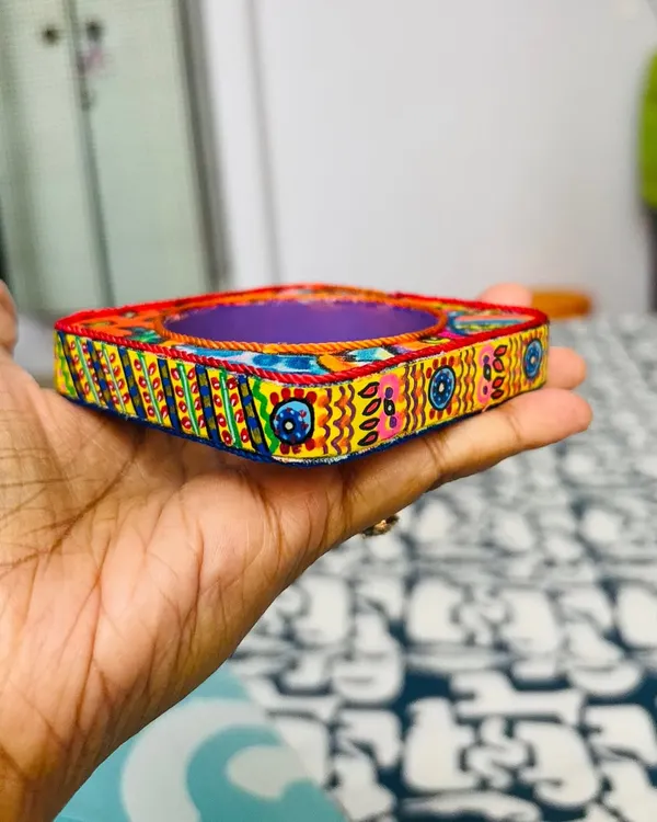 This is my signature Banjara Bangle, a wearable piece of art. I wrap a wooden square bangle in fabric printed with my original psychedelic artwork and finish it with hand-painted details on the rim.