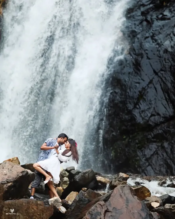 A classic romantic pose in front of a stunning waterfall. The power of the water and the intimacy of the couple's embrace create a beautiful and timeless pre-wedding photo.