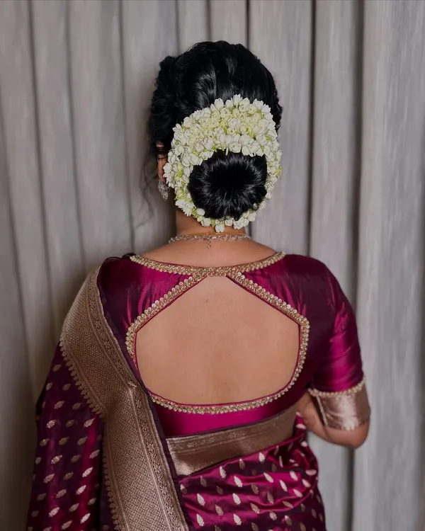 A classic gajra bun is the epitome of traditional elegance. This beautifully crafted hairstyle, full of fresh jasmine, perfectly complements a silk saree for a timeless wedding look.