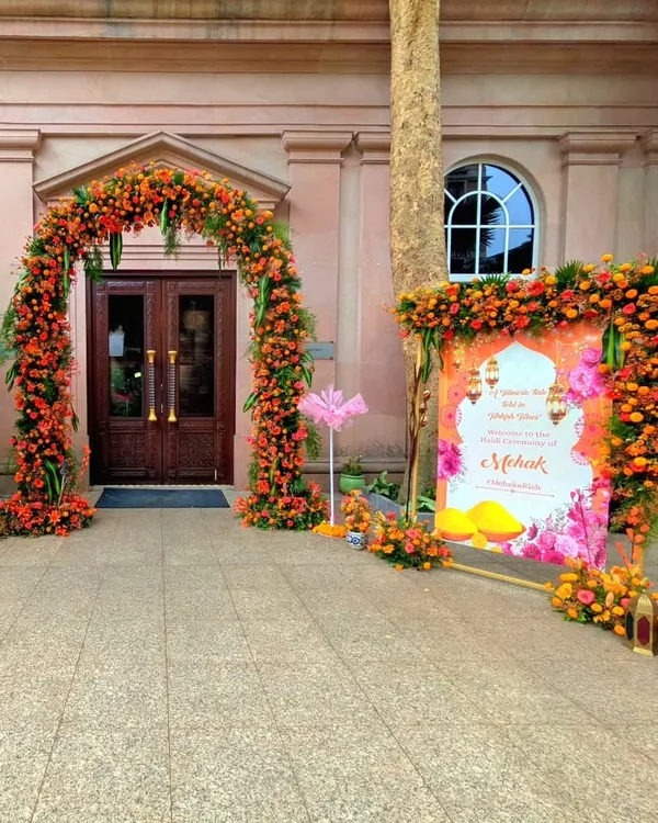 For this unique Haldi ceremony, I designed a vibrant entrance with a Turkish-inspired theme. The floral arch is made of bright orange and yellow marigolds, perfectly complementing the custom-designed welcome signage.