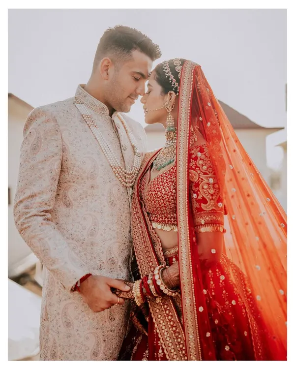 An intimate close-up of the couple, their foreheads touching, capturing a moment of quiet connection in their wedding attire.