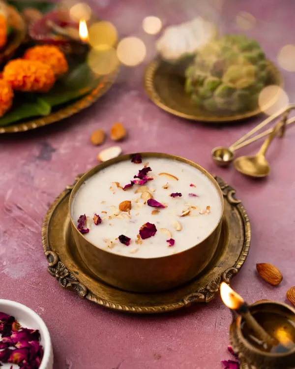 A festive shot of Kheer for Navratri, styled with diyas, marigold flowers, and traditional brassware to create a warm, celebratory mood.