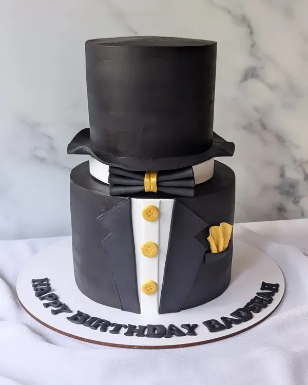 A dapper gentleman's theme cake for a CEO. This design features a sharp tuxedo and a top hat, all handcrafted from fondant.