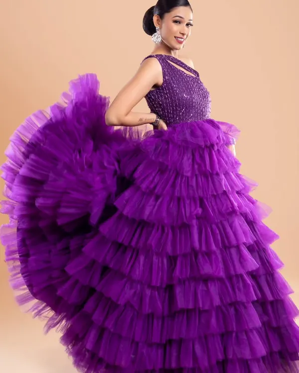 This vibrant purple layered gown is designed to make a statement. The ruffled skirt creates incredible volume and movement, perfect for photos where you want to show off your outfit.