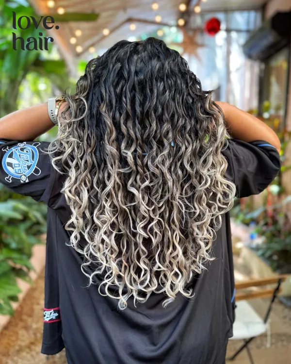 A full view of this incredible silver blonde balayage on long curly hair. We carefully painted each section to create a seamless blend from dark roots to light ends.