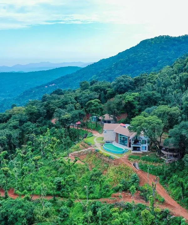 An aerial view of our 'Abode in the Mountains' project in Chikmagalur. The residence is carefully sited to maximize the spectacular views of the Western Ghats while minimizing its impact on the lush landscape.