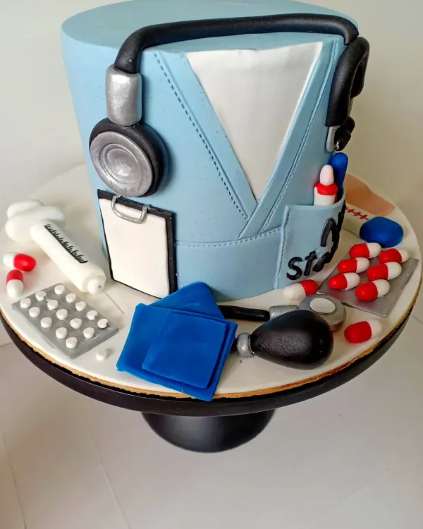 A closer look at the details on my doctor-themed cake. You can see the tiny blister pack of pills, the syringe, and the blood pressure cuff, all handcrafted from fondant to celebrate the healing profession.
