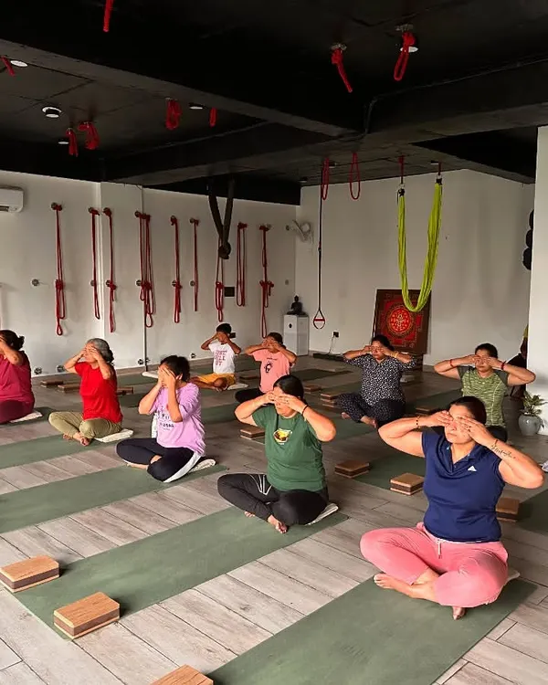 A group of students practicing Bhramari Pranayama (Humming Bee Breath). This technique is incredibly effective at calming the mind, relieving frustration, and preparing the consciousness for meditation by turning the senses inward.
