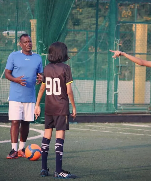 Coach Mani provides specific instructions to two of our academy players during a practice session. This kind of focused, one-on-one feedback helps refine technique and build player confidence.