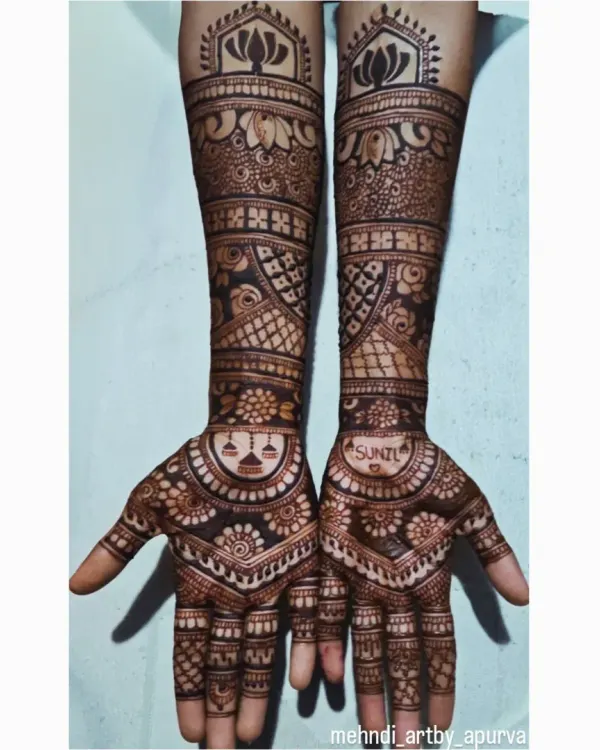 I love creating full forearm mehendi that tells a story. This design combines my signature lotus motif at the top with traditional peacocks and a special personal touch, the groom's name 'Sunil', hidden in the pattern.