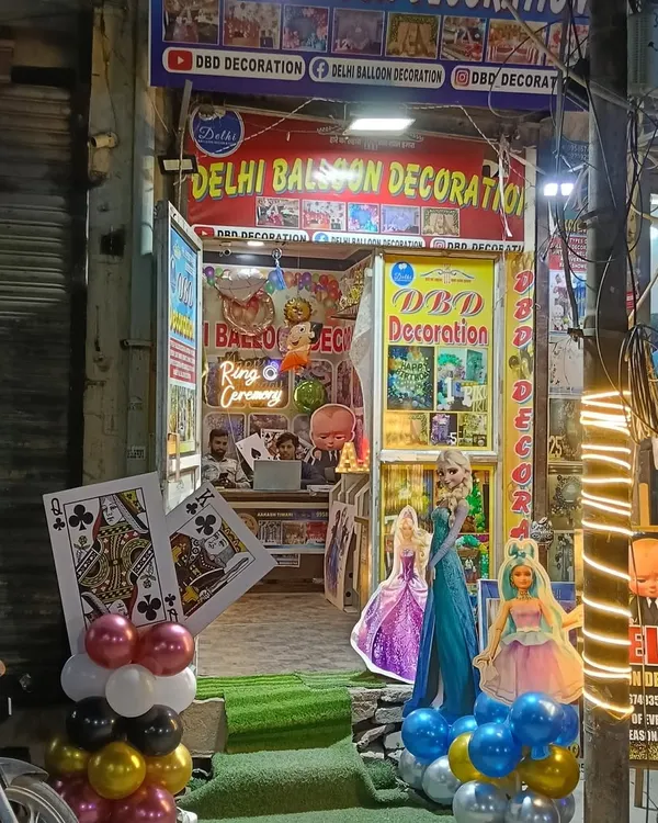 This is my shop, Delhi Balloon Decoration, located at Balaji Chowk in Uttam Nagar. You can see some of the character cutouts and decoration materials I have available.
