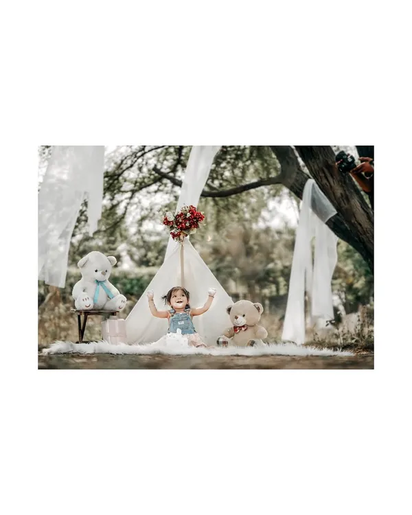 A moment of pure joy in our outdoor teepee setup. This little girl's arms are wide open, embracing the fun of her whimsical teddy bear picnic.
