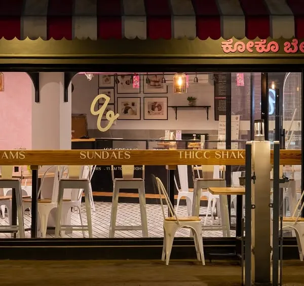 This is the inviting night-time facade of Qoqobae, an ice cream parlor in Bengaluru. I designed it to have the charm of a French cafe, using a distinct color palette and warm lighting to create a welcoming glow that stands out on the street.
