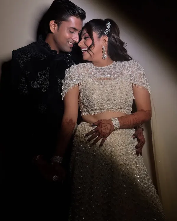 A candid moment of joy from a Sangeet night. Her makeup features soft glam eyes and a radiant base that stays perfect through all the dancing, complemented by a half-up hairstyle with a statement clip.