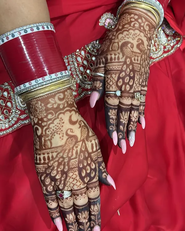 A beautiful Karwa Chauth design featuring peacocks and a crescent moon. The fine line work and shaded details make the motifs stand out.