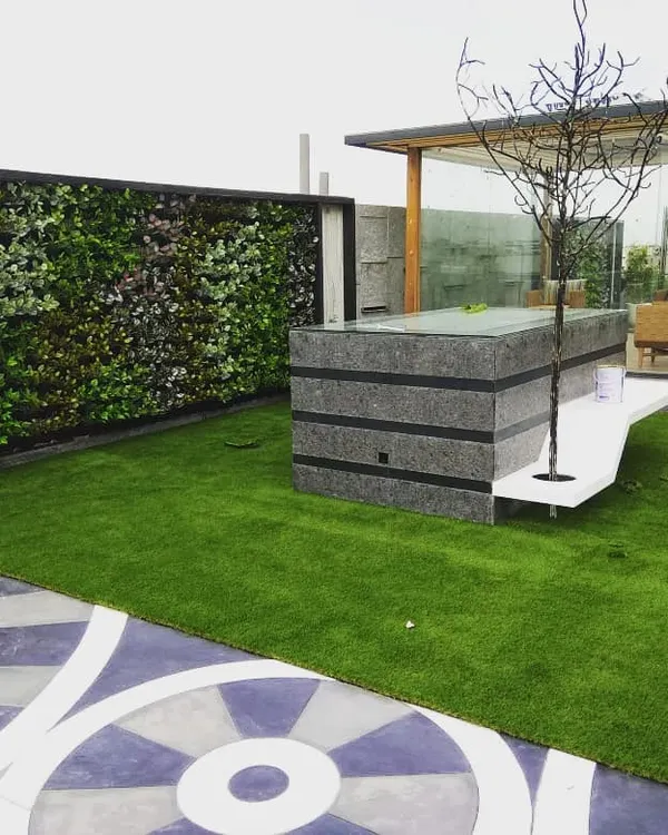 This is a prime example of a complete terrace transformation. We installed soft artificial grass, a full-sized artificial green wall for privacy, and arranged the space around a central water feature and gazebo.