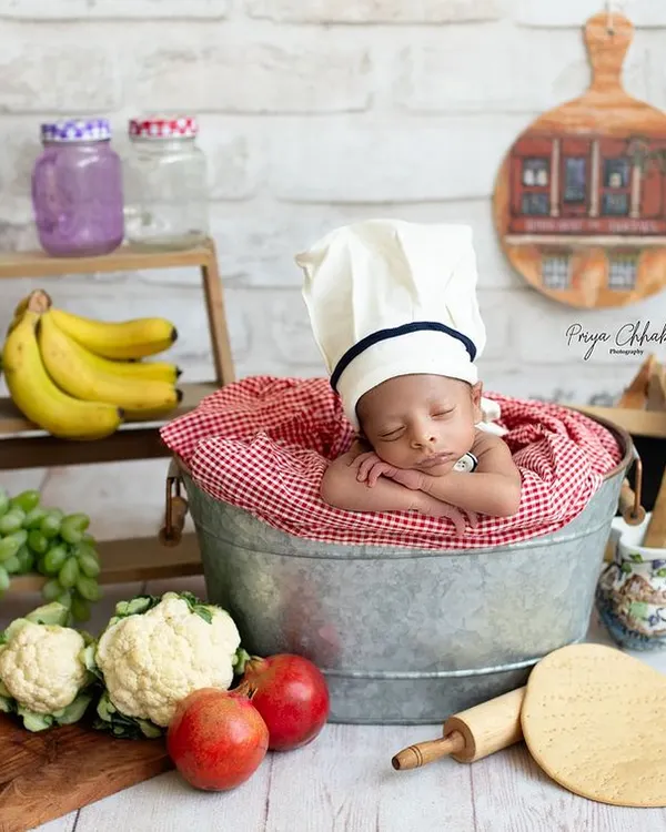 Cooking up some cuteness in the studio! This little chef is the main ingredient in our recipe for a perfect newborn photo, complete with a tiny chef's hat and a kitchen full of props.