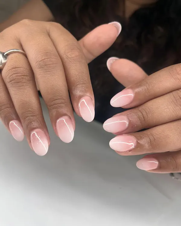 A classic and delicate baby boomer manicure, also known as French ombré, with a seamless blend from pink to white on short, rounded nails.