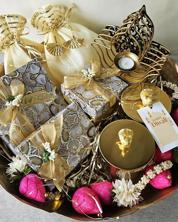 This is the essence of my craft, a grand festive hamper brimming with joy. Inside this beautiful basket, you will find agate-printed gift boxes, gourmet treats in delicate potlis, and an elegant hamsa-shaped candle holder, all curated to make your celebration truly unforgettable.