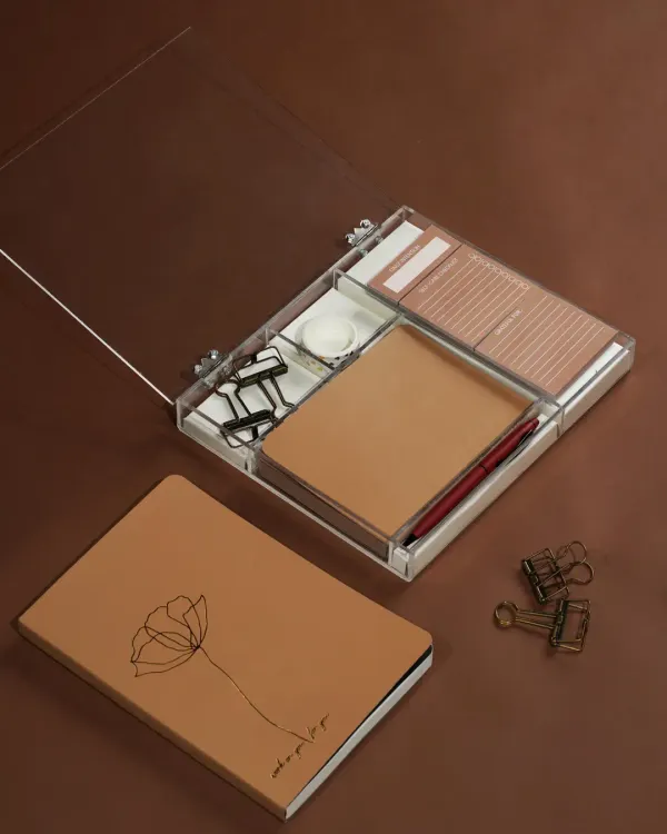 A modern stationery set featuring a journal and an acrylic organizer, styled with minimalist clips and a pen. The clean, brown-toned aesthetic is perfect for a sophisticated, organized workspace.