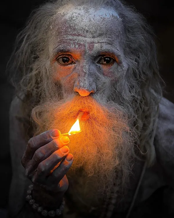 A sadhu's face illuminated only by the flame of a matchstick. This portrait uses light and shadow to create a sense of mystery and deep contemplation, a signature style in my work.