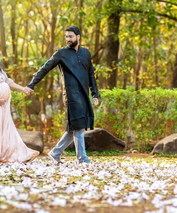 A romantic walk through a field of fallen blossoms. This shot captures the couple hand in hand, creating a beautiful narrative of their journey together in a stunning natural setting.