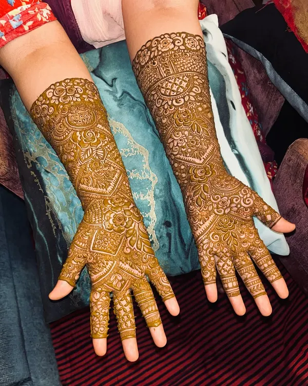A classic, full-coverage Indian mehendi design. The patterns are dense and detailed, featuring traditional motifs that extend to the elbows.