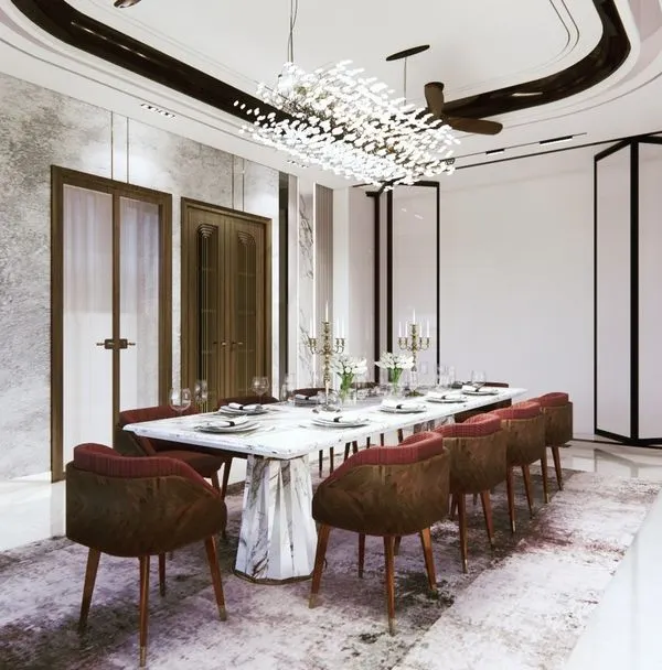 A dining room designed for abundance and connection. The spacious layout, luxurious marble table, and brilliant chandelier are not just aesthetic choices; they are Vastu elements intended to foster prosperity and harmonious family gatherings.