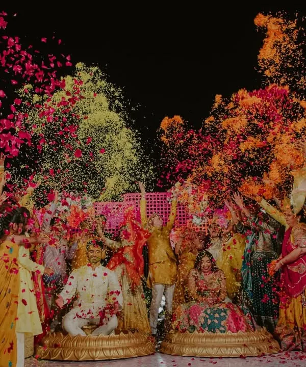 A moment of pure, unadulterated joy. We believe in capturing the beautiful chaos, and this vibrant shower of flower petals during the Haldi ceremony is a perfect example of the energy and happiness that fills a wedding.