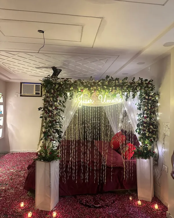 This is the kind of breathtaking "welcome bride" setup I love to create. I combine a lush floral canopy with a custom neon sign, delicate light strings, and a floor blanketed in rose petals to make the first night truly unforgettable.