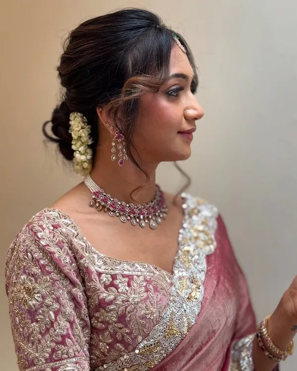 A gorgeous and modern look for Monica. We chose a soft glam style with a messy bun adorned with flowers, perfect for her elegant designer saree. This look is completely filter-free.