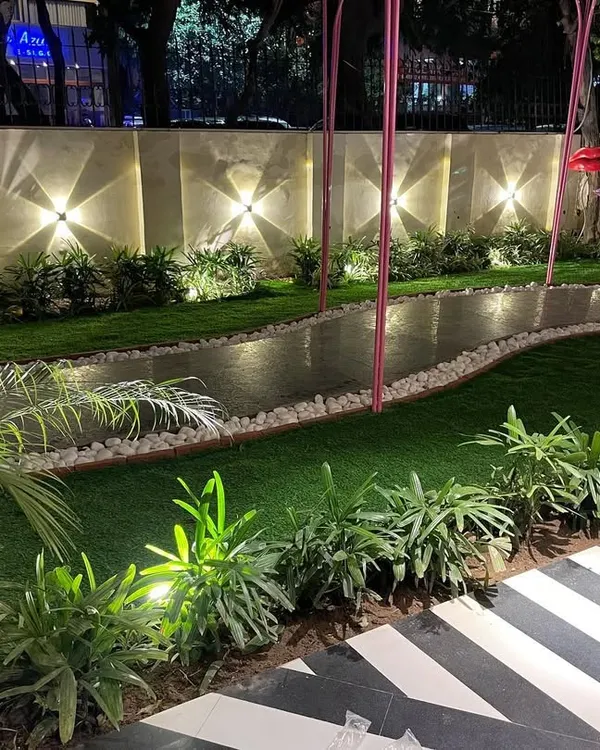 A beautifully lit garden path at night. I used a combination of wall-mounted uplights and low-level spotlights to illuminate the walkway, the surrounding plants, and the boundary wall, creating a magical atmosphere.