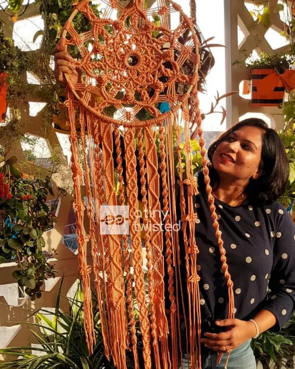 Holding up this 4-foot-tall dreamcatcher gives a true sense of its scale. The intricate knotting in the center contrasts beautifully with the long, flowing tassels.