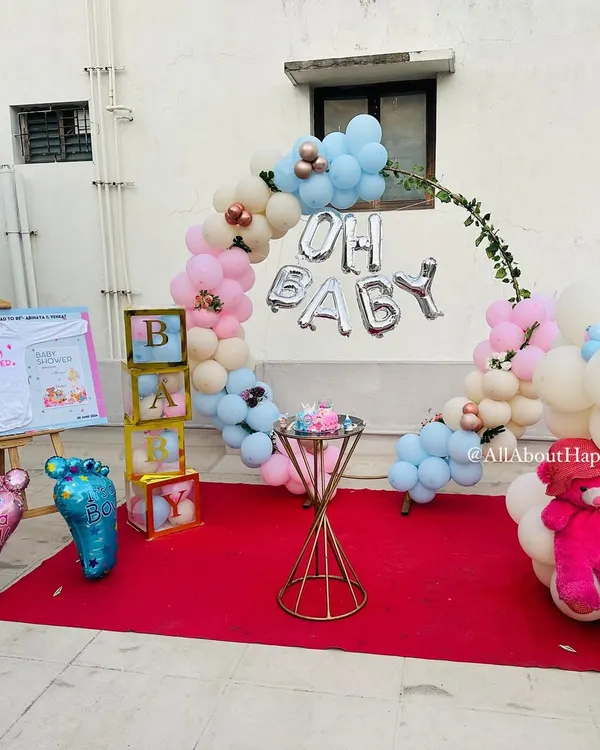 A beautiful 'Mottamadi' or terrace baby shower setup. The decor includes a lovely balloon hoop, 'Oh Baby' foil balloons, and a personalized easel board.