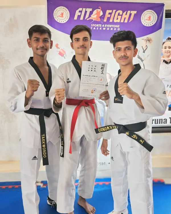 Three of our senior students pose with a certificate after a successful belt exam. Reaching the red and black belt levels is a significant achievement that requires years of dedication.