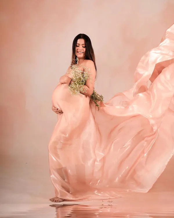 A stunning portrait using a flowing peach organza drape, creating a sense of movement and ethereal beauty.