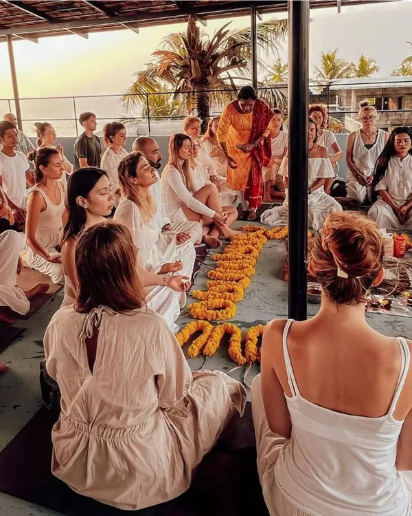 This is what our kulam is all about. Students gather for a morning meditation session on a rooftop shala in Kerala, surrounded by marigold garlands, ready to start a day of learning and self-discovery. This sense of community and shared intention is at the core of every retreat.