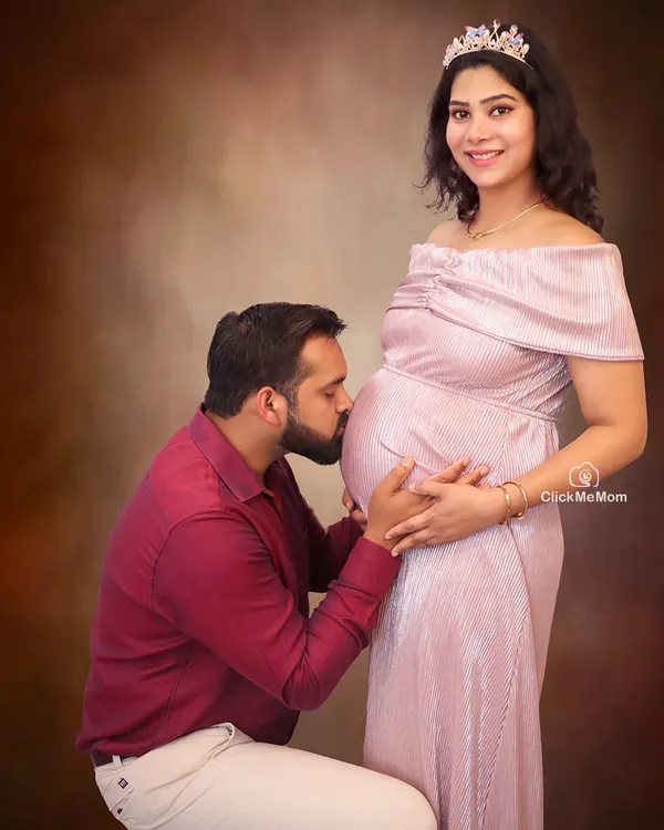A tender kiss for the precious life within. This pose is a beautiful way for partners to show their love and anticipation for the baby. It creates a classic and emotional family maternity portrait that you will cherish forever.