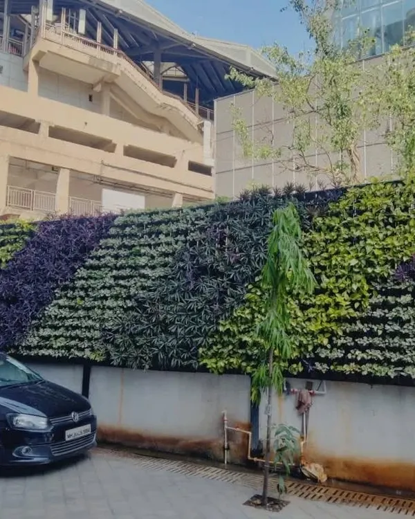 This large-scale exterior green wall uses a diagonal pattern of purple and green foliage to create a dynamic visual effect. It's a powerful way to beautify large structures and make a positive environmental impact.