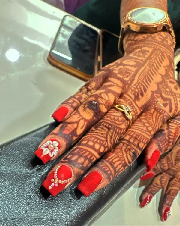 A classic bridal look featuring bold red nails that stand out beautifully against the dark mehndi stain. I added a 3D floral accent nail and another with a delicate, jewelry-inspired stone pattern.