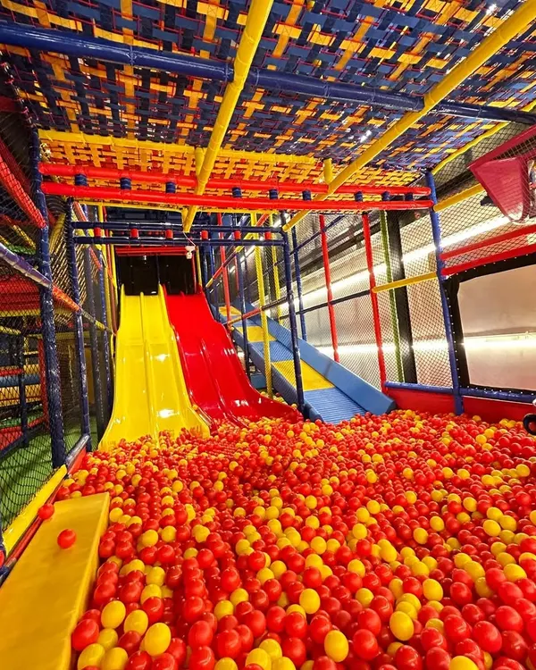 Welcome to our multi-level play paradise. This wide view shows our exciting slides plunging into a massive ball pit, just a glimpse of the adventure that awaits your children in our fully air-conditioned, safe play zone.