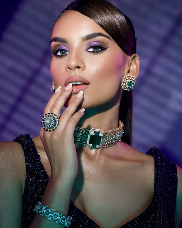 A study in modern glamour. This shot captures the power of a bold look, using dramatic lighting to sculpt the face and highlight the intricate details of the emerald and diamond jewelry. This is where makeup artistry meets high-fashion editorial.