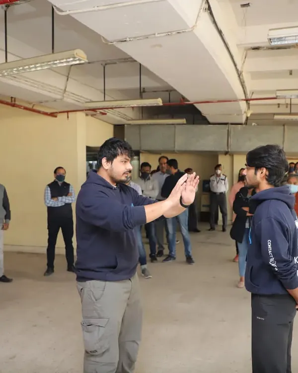 During an on-site corporate training session, I am explaining the importance of maintaining a safe distance from a potential aggressor. This foundational skill is crucial for preventing a physical confrontation.