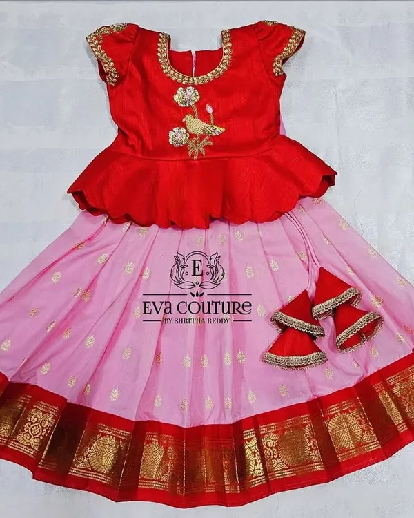 A ready-to-ship pattu pavadai for newborns to 1-year-olds. This red and pink set has a peplum top with bird embroidery and comes with extra margins to be used for up to 2.5 years.
